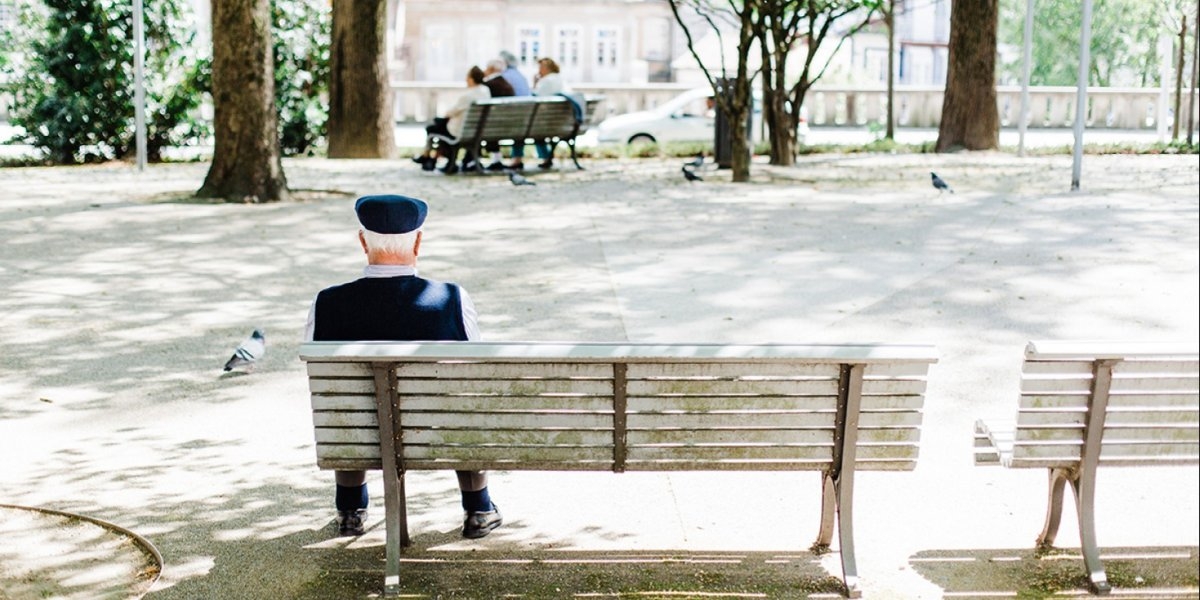 EN GAMMEL MANN HVILER I VARMEN I GUIMARAES, PORTUGAL