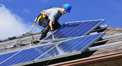 Man on a roof with solar panels